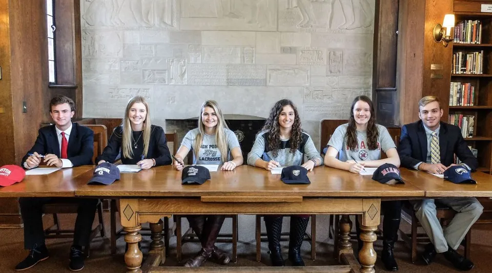 Sei studenti e studentesse lavorano insieme a un tavolo di legno nella biblioteca della Cranbrook Schools.