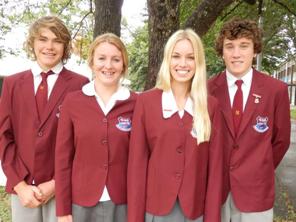 Quattro studenti della Pittwater High School posano insieme all'aperto davanti agli alberi.