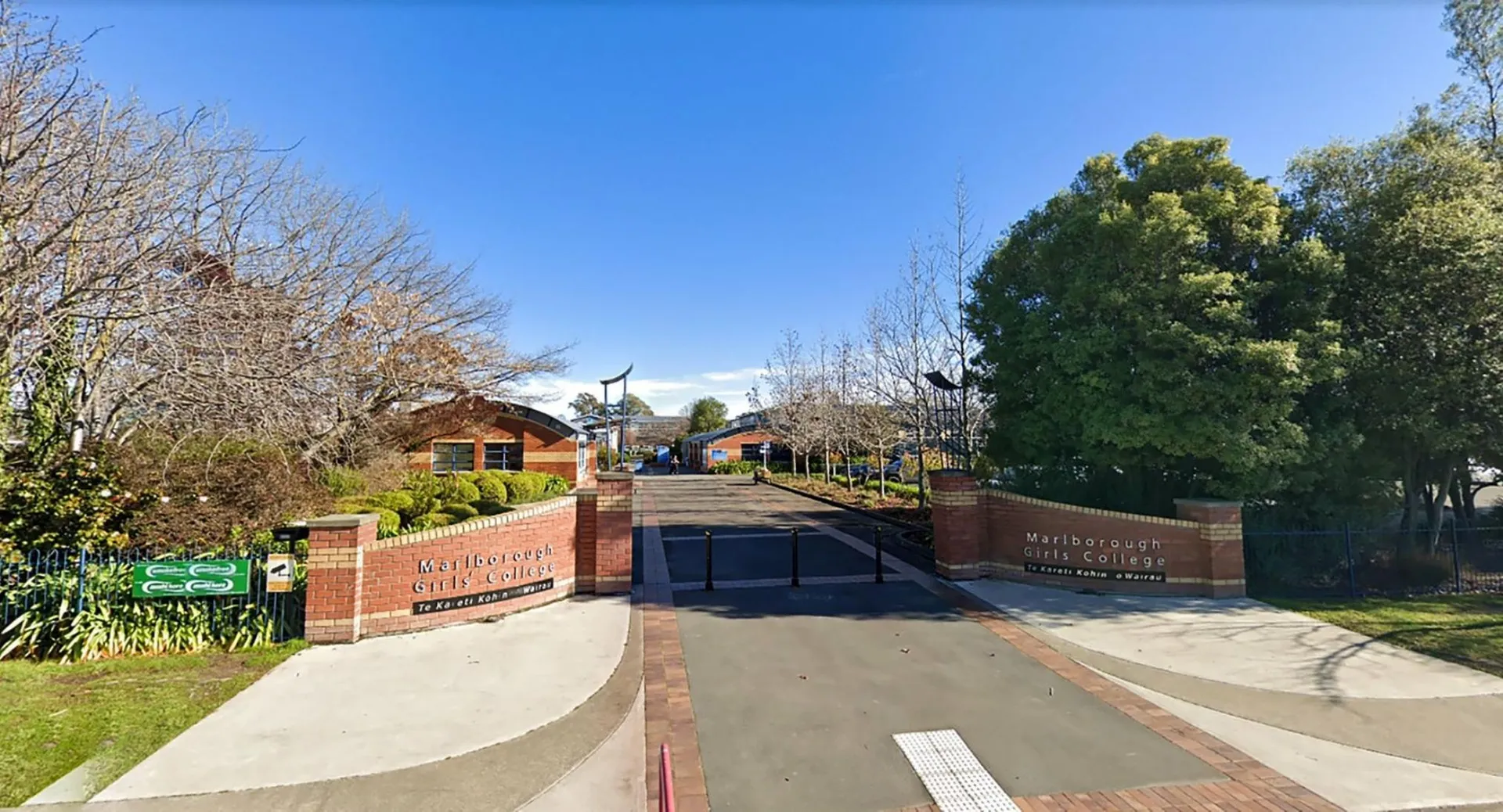 Un sentiero pavimentato attraversa un paesaggio verde all'interno del campus della Marlborough Girls School.