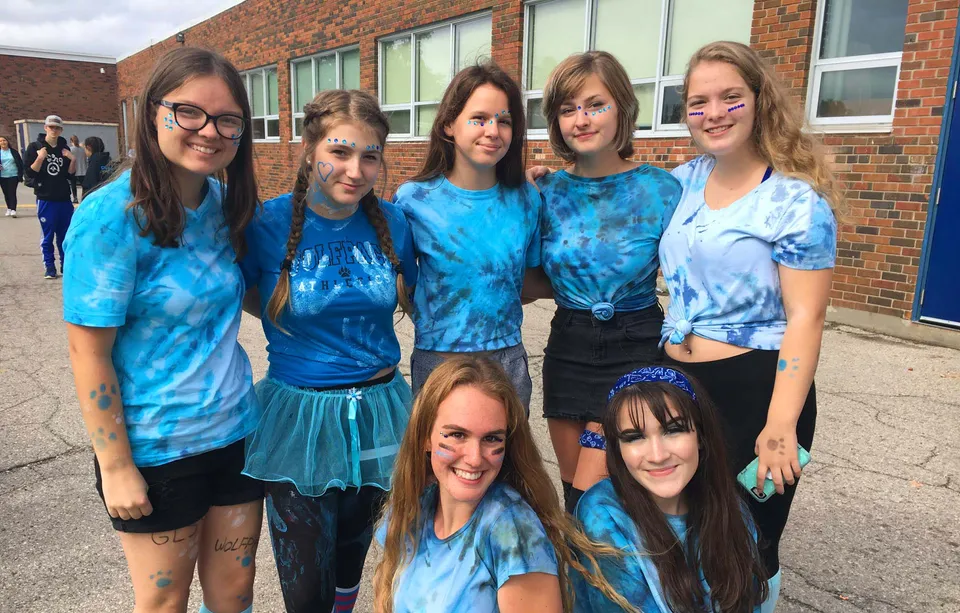 Un gruppo di studentesse della Great Lakes District Secondary School sta davanti a un edificio in mattoni.