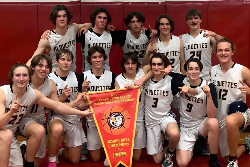 Un gruppo di giovani giocatrici di basket del Collège Notre-Dame posa insieme con una coppa davanti a uno sfondo rosso.