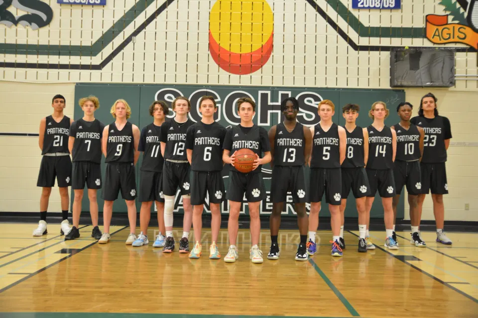 Gruppenfoto von dem männlichen Basketballteam der Spruce Grove Composite High School in der Sporthalle