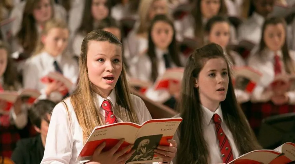 Studenti e studentesse della Mary Erskine School cantano insieme nel coro su un palco.