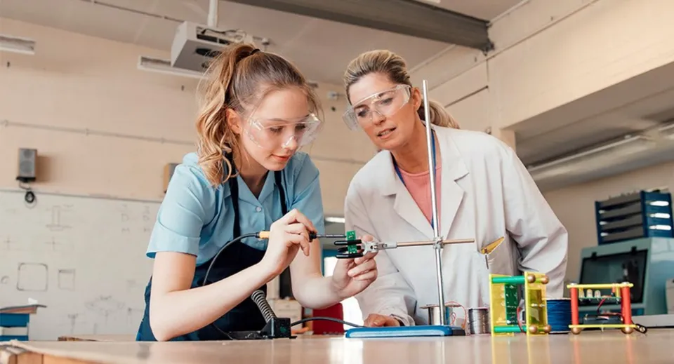 Due donne in abbigliamento medico lavorano insieme nel laboratorio della Earl of March Secondary School con attrezzature scientifiche.