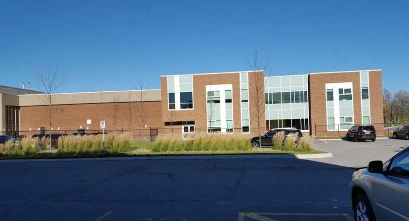 L'edificio scolastico a più piani della Earl of March Secondary School con facciata in mattoni e vetro e parcheggio pavimentato in primo piano.
