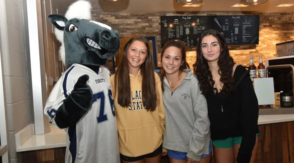 Studentesse della Forsyth Country Day School posano con la grande mascotte in un locale per il tempo libero.