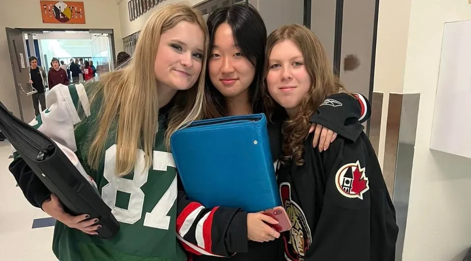 Tre studentesse della Rockland District High School si abbracciano nel corridoio della scuola.