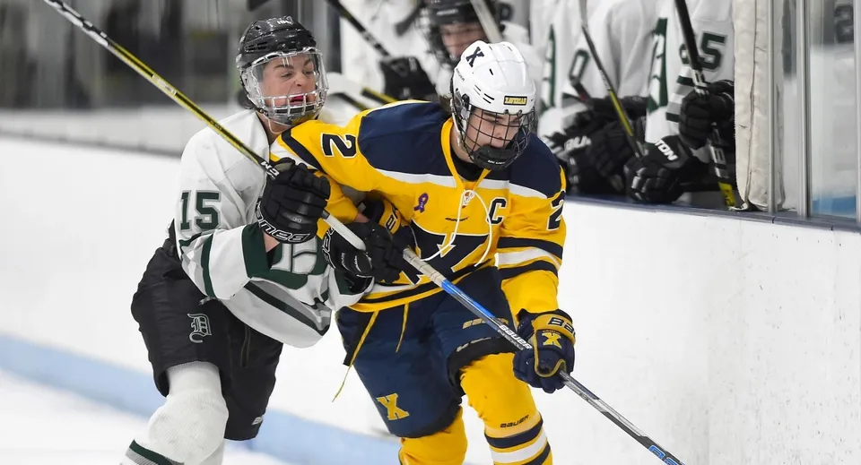 Due giocatori di hockey della H.B. Beal Secondary School lottano sul ghiaccio per il puck.