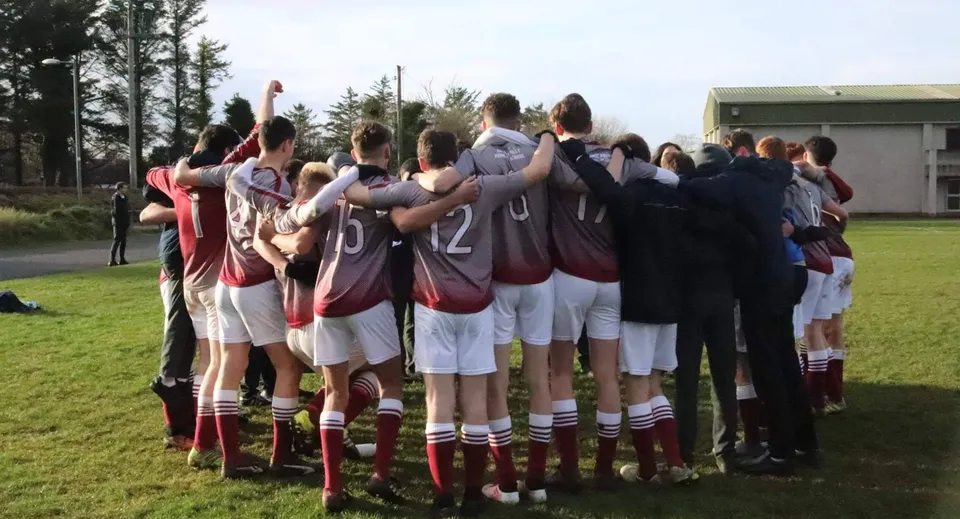Un gruppo di studenti è radunato su un campo sportivo nei terreni della Grange Post Primary School.