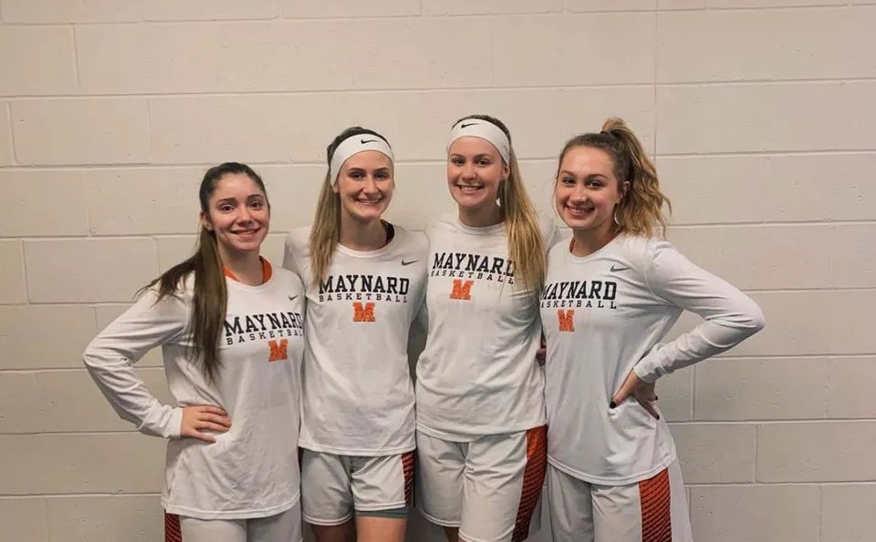 Quattro studentesse della Maynard High School in maglia da basket insieme negli spogliatoi.