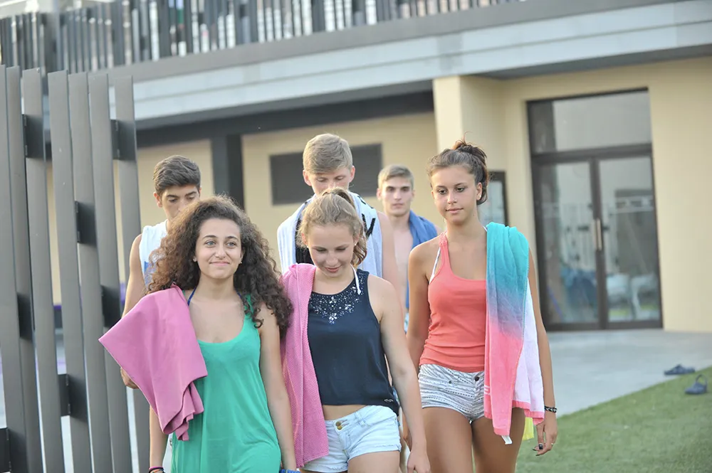 Jugendliche mit Handtüchern auf dem Weg zum Pool auf dem Campus in Málaga