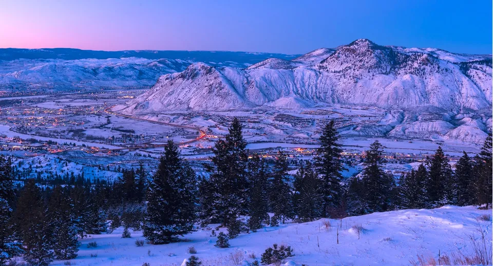 Una catena montuosa innevata si trova sullo sfondo sopra la pittoresca cittadina nella valle vicino alla Clearwater Secondary School.