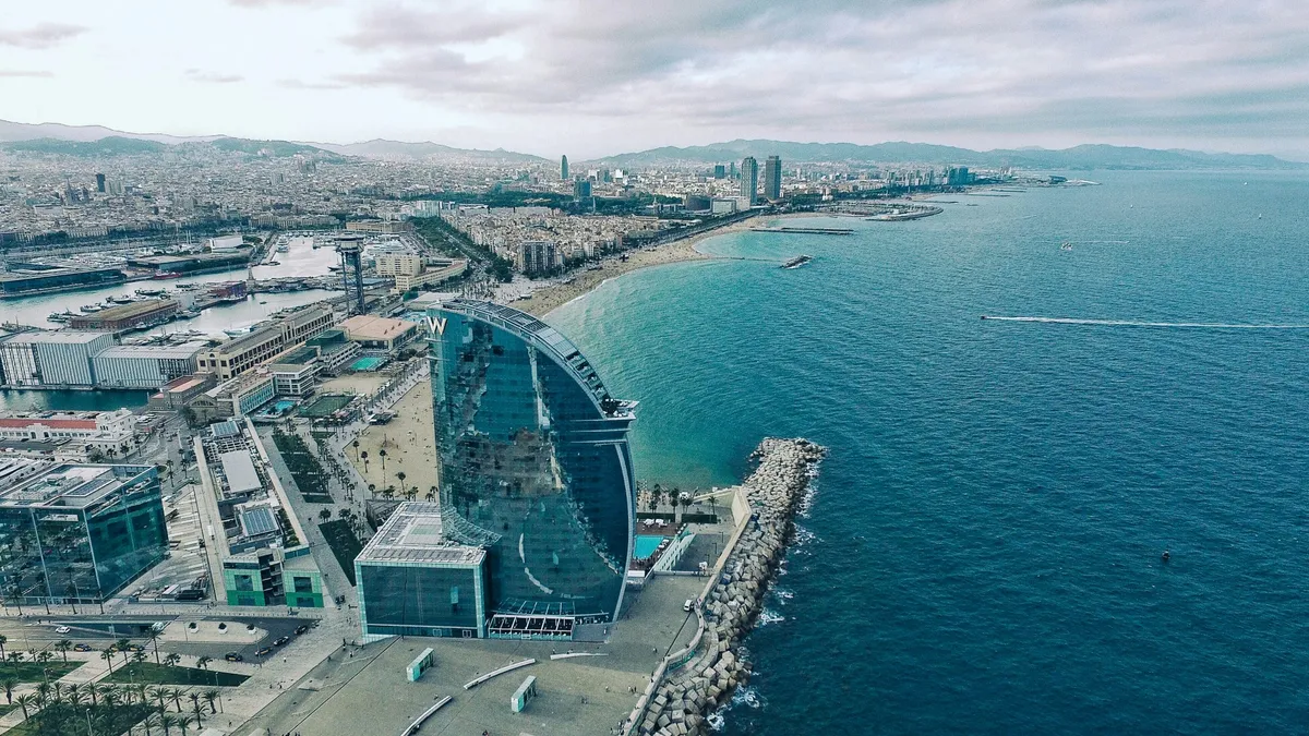 Veduta dall'alto della spiaggia della Barceloneta con l'hotel a vela e il porto olimpico