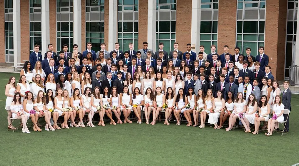 Un gruppo di studenti della Sidwell Friends School sta su un prato davanti a un edificio in mattoni.