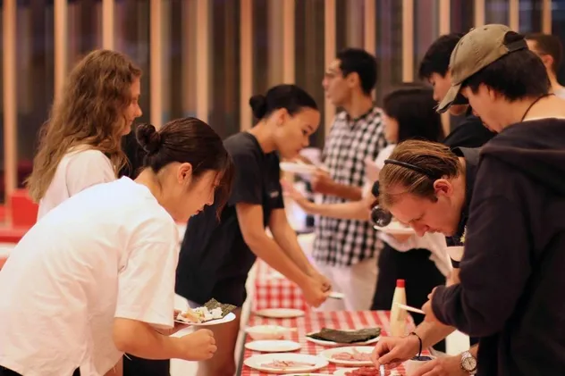 Schülerinnen und Schüler bedienen sich an einem Buffet in Japan