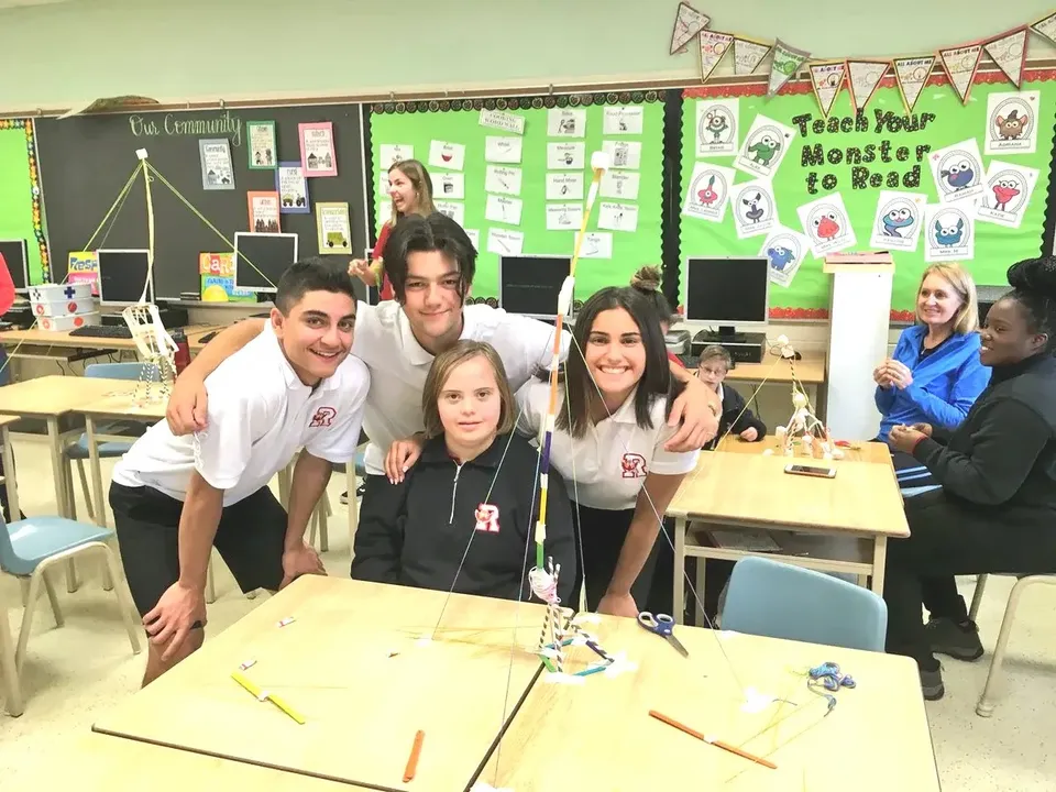 Un gruppo di studenti della Resurrection Catholic School lavora insieme a un tavolo in un'aula colorata.