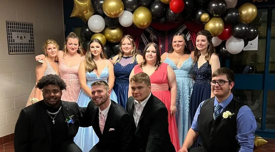 Un gruppo di studenti della St. Lawrence Secondary School posa davanti a uno sfondo di palloncini colorati.