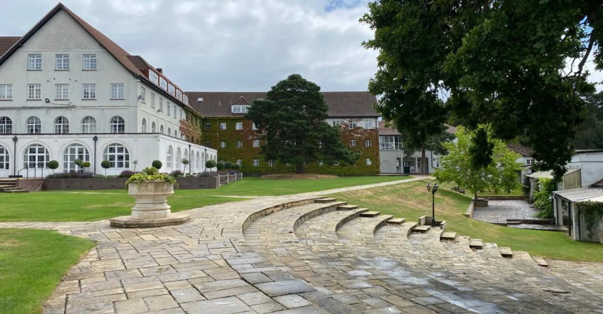 Il cortile interno con un vialetto pavimentato e un'architettura storica nel campus della Downe House School.