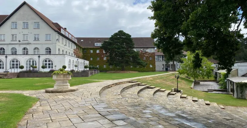Il cortile interno con un vialetto pavimentato e un'architettura storica nel campus della Downe House School.