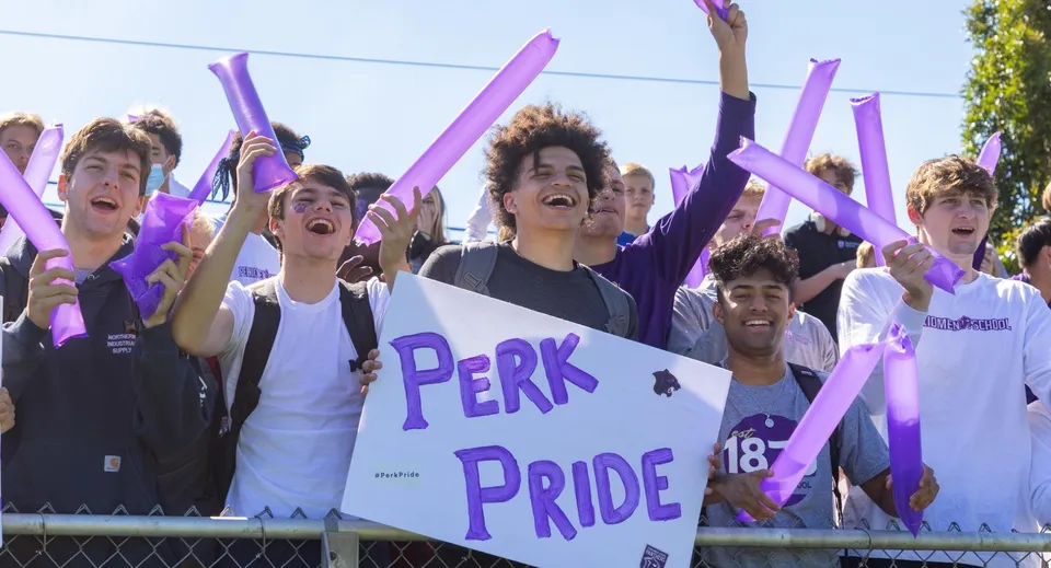 Studenti della Perkiomen School festeggiano all'aperto con bandiere viola e cartelli durante un evento Pride.