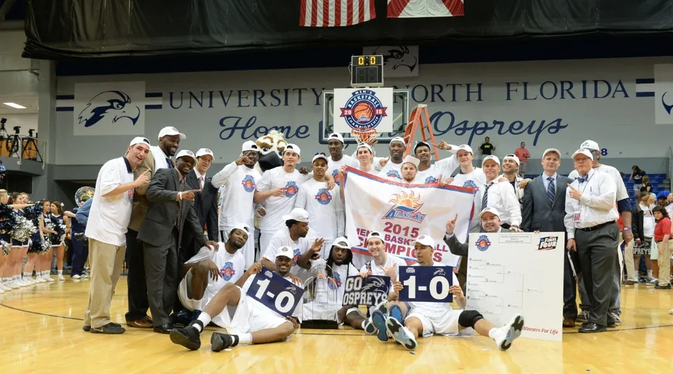 Studenti della University of North Florida festeggiano la loro vittoria sul campo da basket con uno striscione del campionato.