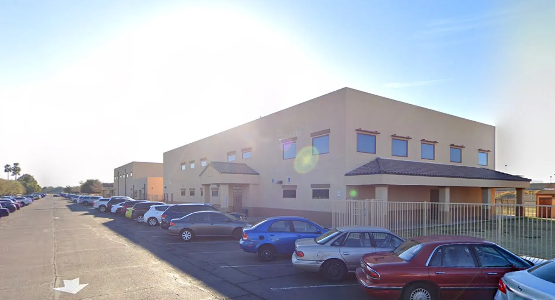 L'edificio scolastico a più piani della Sequoia Charter High School con il parcheggio e le auto in primo piano.