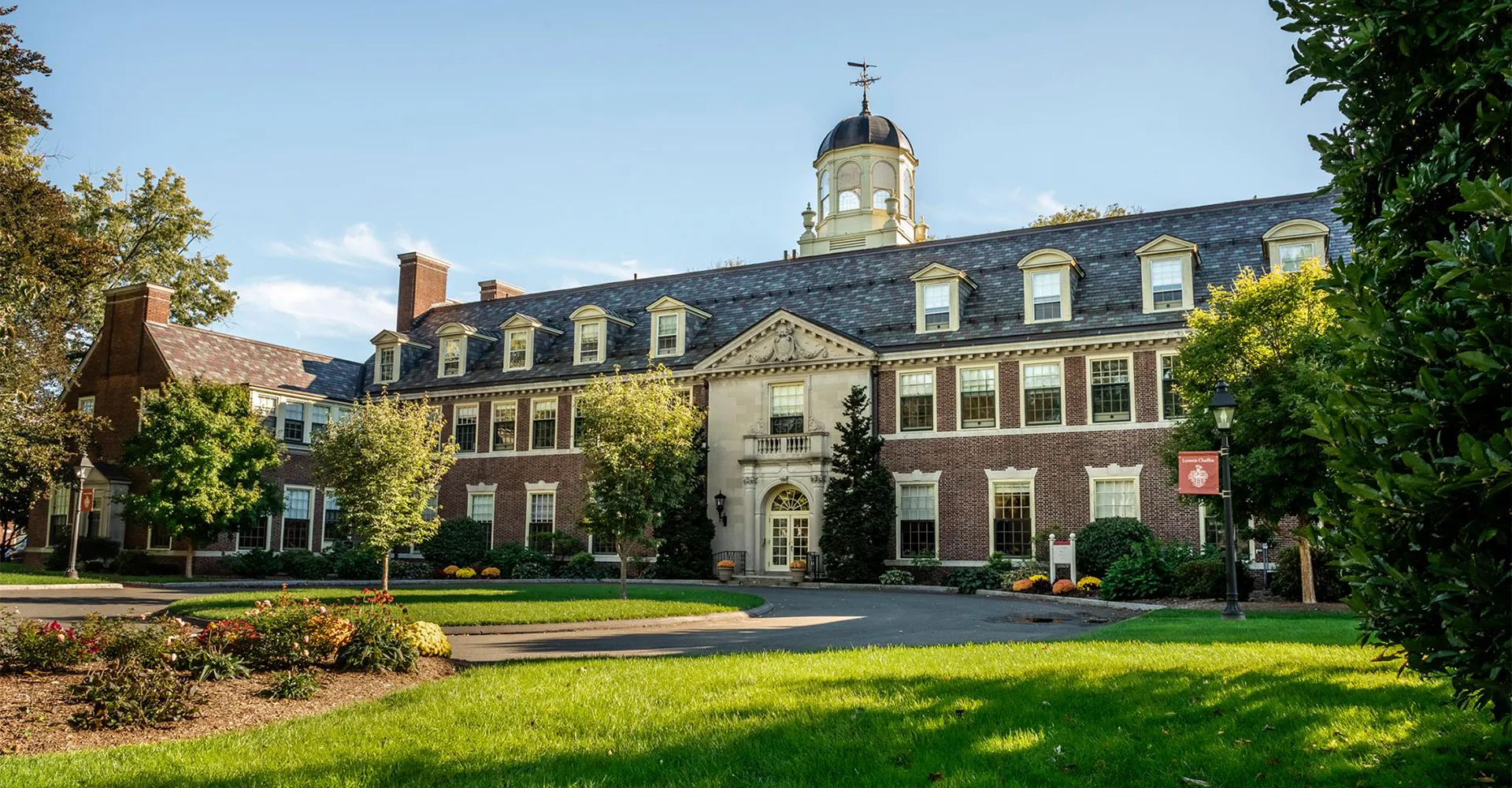 Lo storico edificio con torre dell'orologio nel campus della Loomis Chaffee School è circondato da un curato verde.