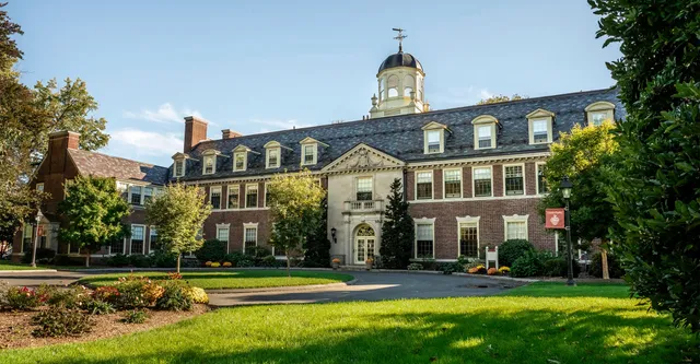 Lo storico edificio con torre dell'orologio nel campus della Loomis Chaffee School è circondato da un curato verde.