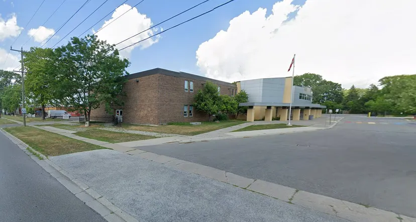 L'edificio in mattoni con un moderno ampliamento si trova lungo una strada alberata del Northern Collegiate Institute & Vocational School.
