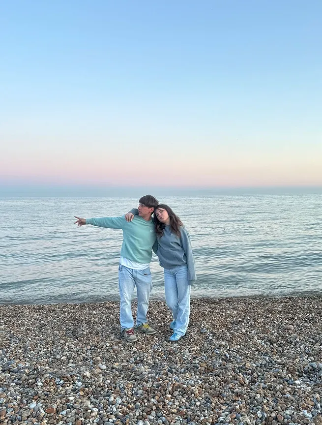 Due studenti su una spiaggia di ciottoli al tramonto in Inghilterra