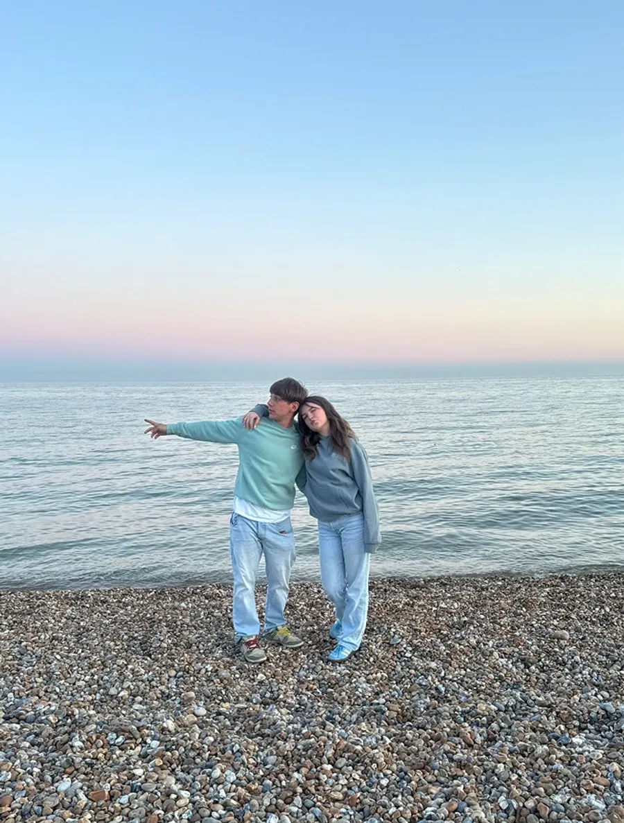 Due studenti su una spiaggia di ciottoli al tramonto in Inghilterra