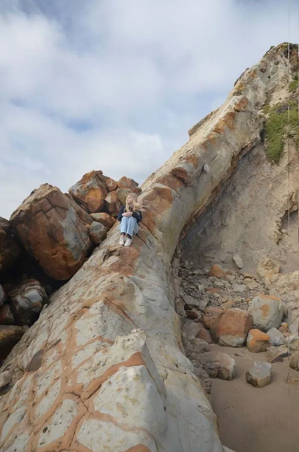 Schülerin auf einem Felsen