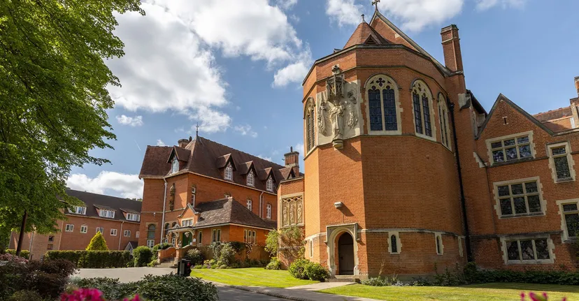 La chiesa con un'alta torre sorge circondata da giardini verdi all'interno del campus della St. Mary’s School Ascot.
