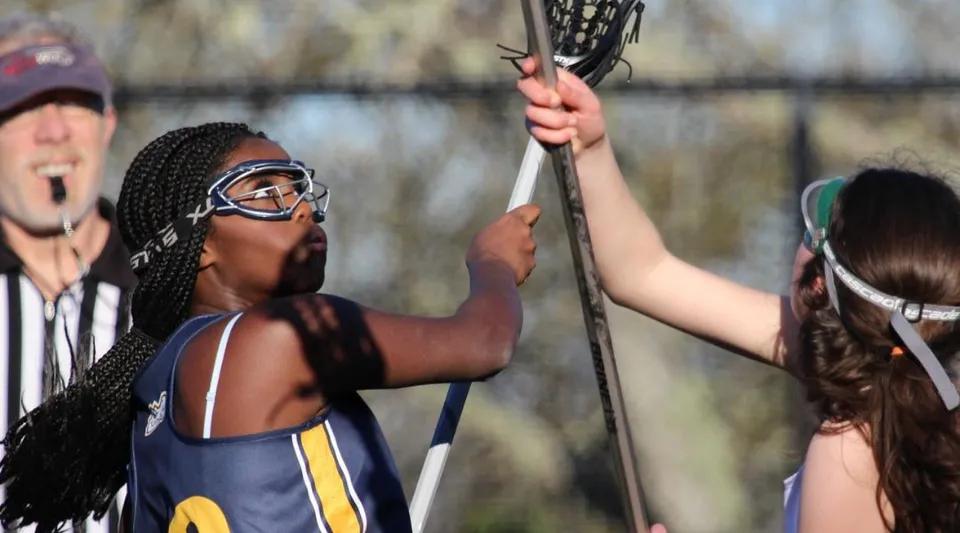 Due studentesse delle Annie Wright Schools giocano a lacrosse sul campo da gioco.
