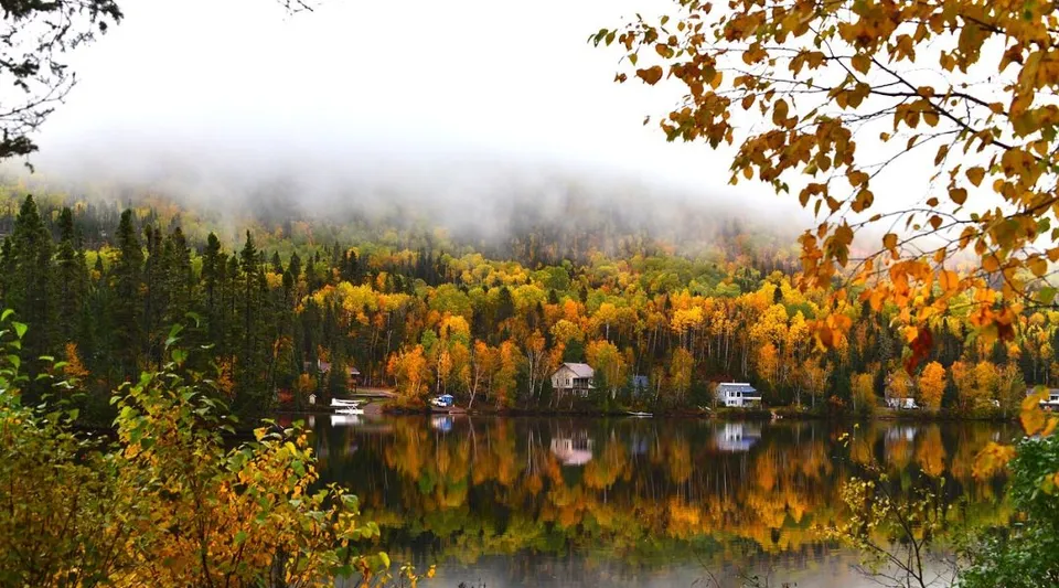 Un lago tranquillo circondato da fogliame autunnale davanti a colline boscose nei pressi della Westwood High School.