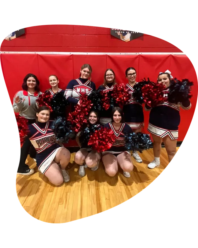 Squadra di cheerleader di una high school americana con pon pon in palestra durante uno scambio