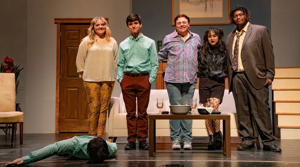 Cinque studenti del Brookdale Community College sono su un palco teatrale mentre un'altra persona giace a terra.