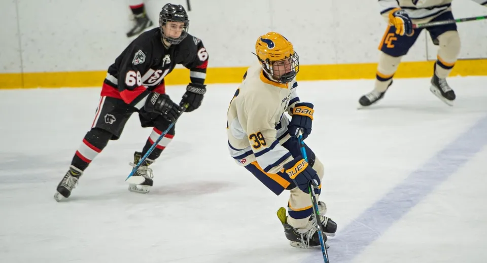 Due giocatori di hockey con maglie diverse giocano sul ghiaccio della Tecumseh Vista Academy.