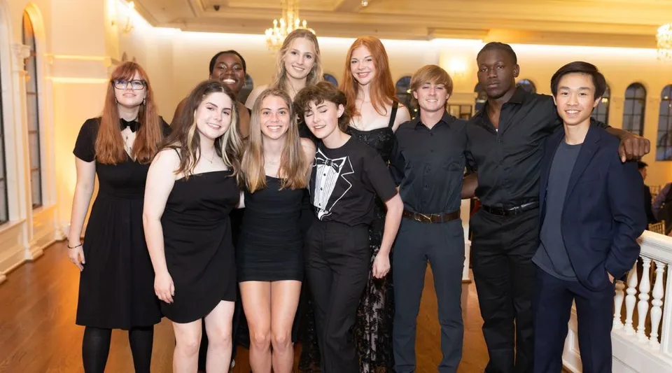 Un gruppo di studentesse della Indian Springs School posa in una stanza formale con dettagli architettonici decorati.