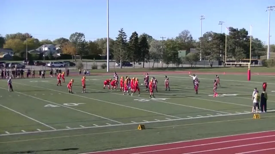 Due squadre con maglie rosse e bianche giocano sul campo sportivo della M.M. Robinson High School.