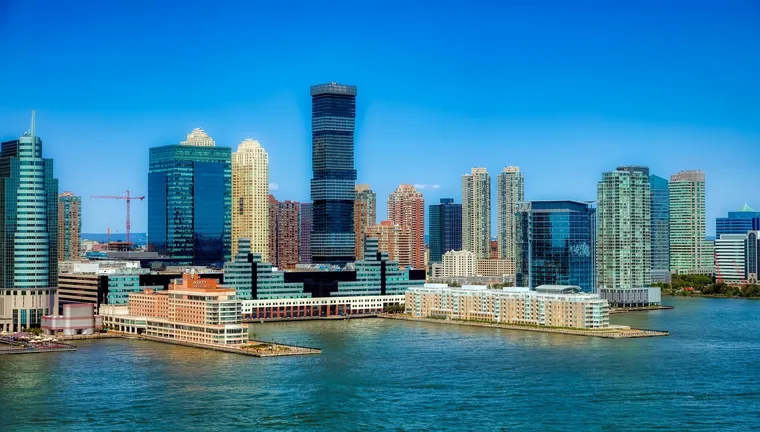 Skyline mit Hochhäusern am Wasser unter strahlend blauem Himmel