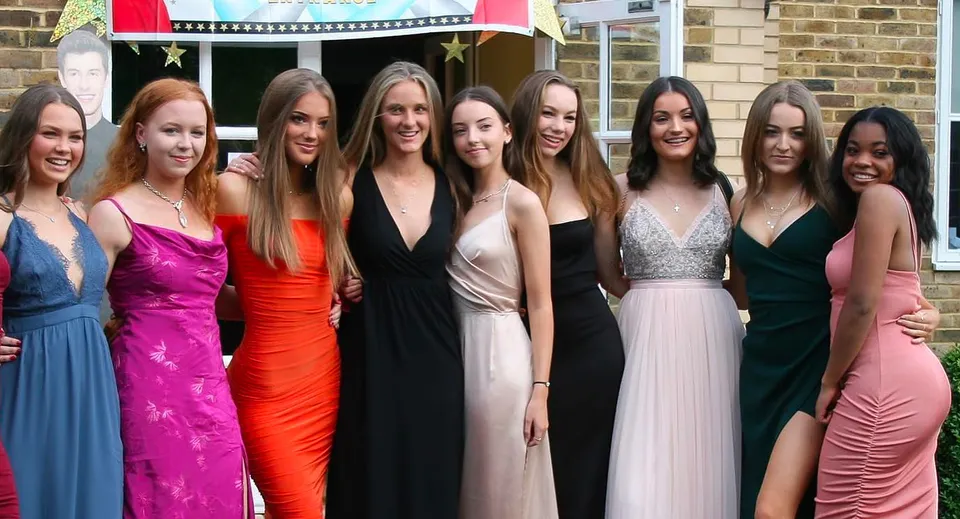 Un gruppo di giovani alunne della Farlington School posa davanti a uno sfondo festivo.