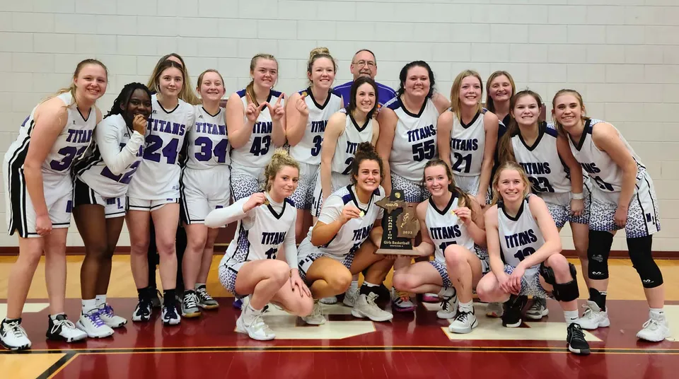 Studentesse della Michigan Lutheran High School festeggiano la loro vittoria sul campo da basket con un trofeo.