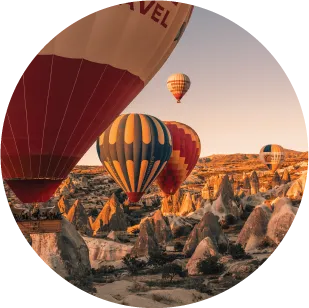 Globos aerostáticos sobrevolando el paisaje rocoso de Capadocia al amanecer