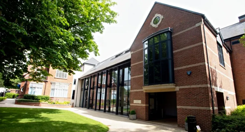 L'edificio in mattoni della Lincoln Minster School si trova davanti a un prato verde ed è circondato da alberi.