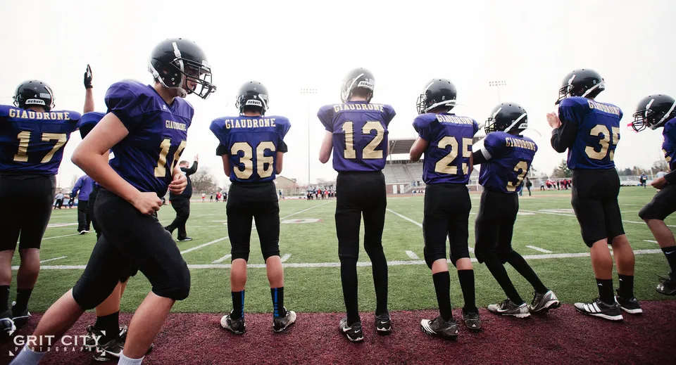 Un gruppo di giocatori di calcio delle Tacoma Public Schools riunito sul campo di gioco in uno stadio.