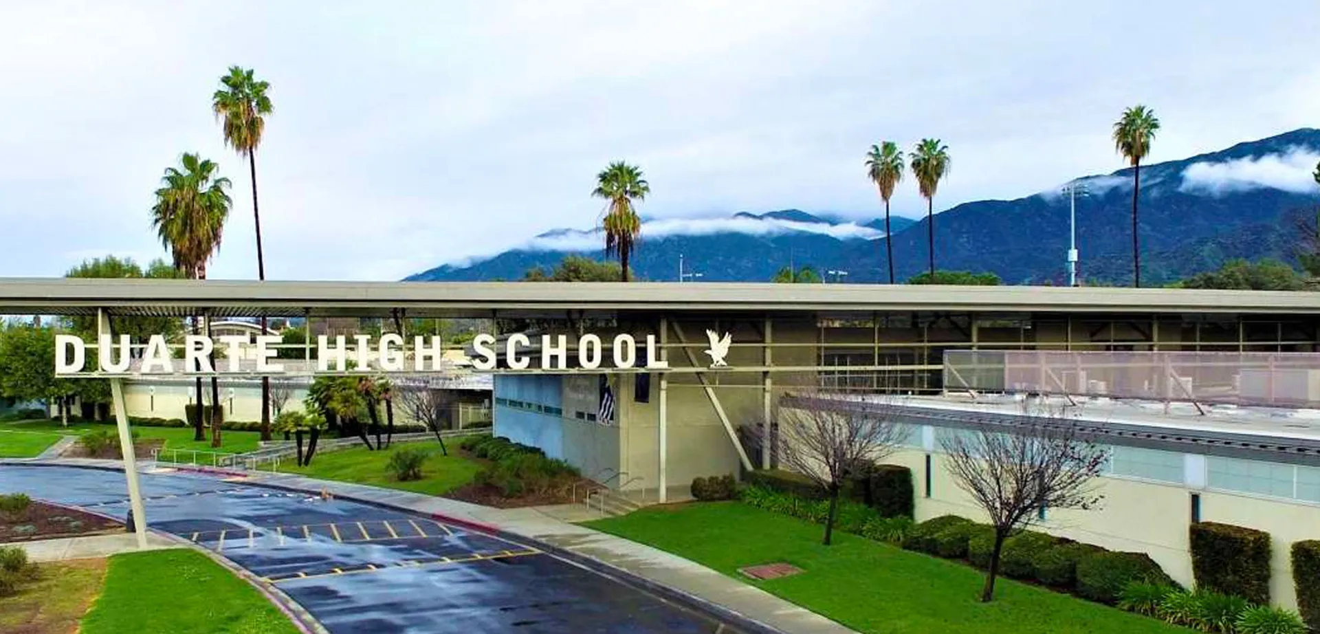 Si vede il campus del Duarte Unified School District con palme in primo piano e montagne sullo sfondo.
