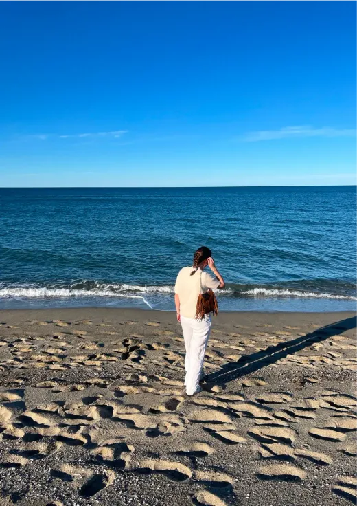 Mädchen geht an einem Strand am Meer entlang in Frankreich