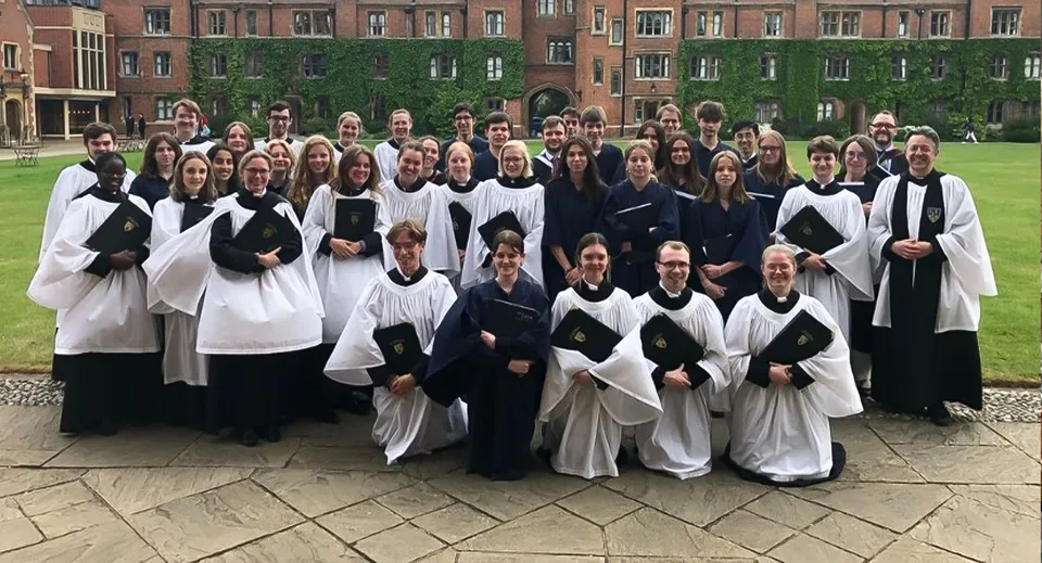 Un gruppo di studenti della The Leys School indossa toghe accademiche davanti a un edificio storico.