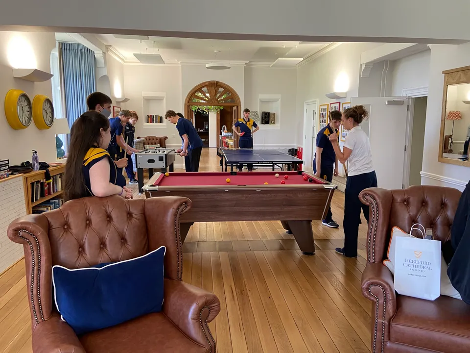 Gli studenti della Hereford Cathedral School si riuniscono in una sala ricreativa con un tavolo da biliardo e posti a sedere.